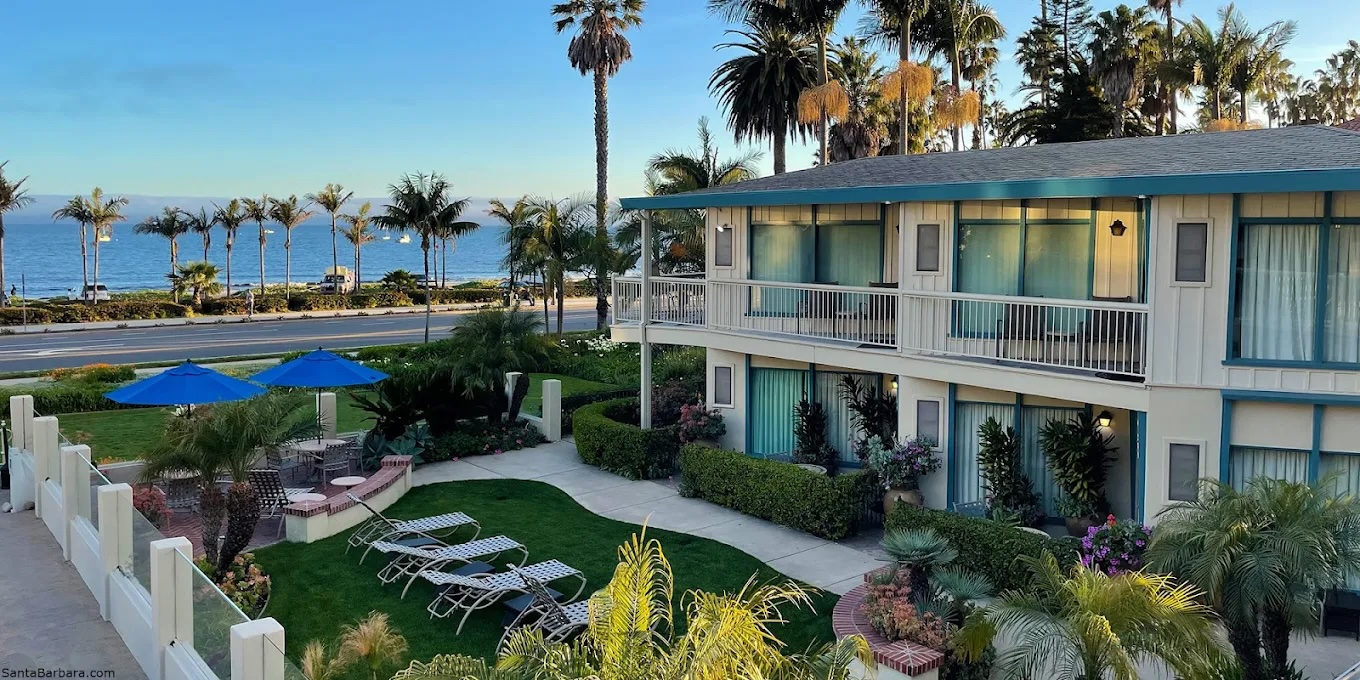 Cabrillo Inn courtyard with palm trees and ocean view.